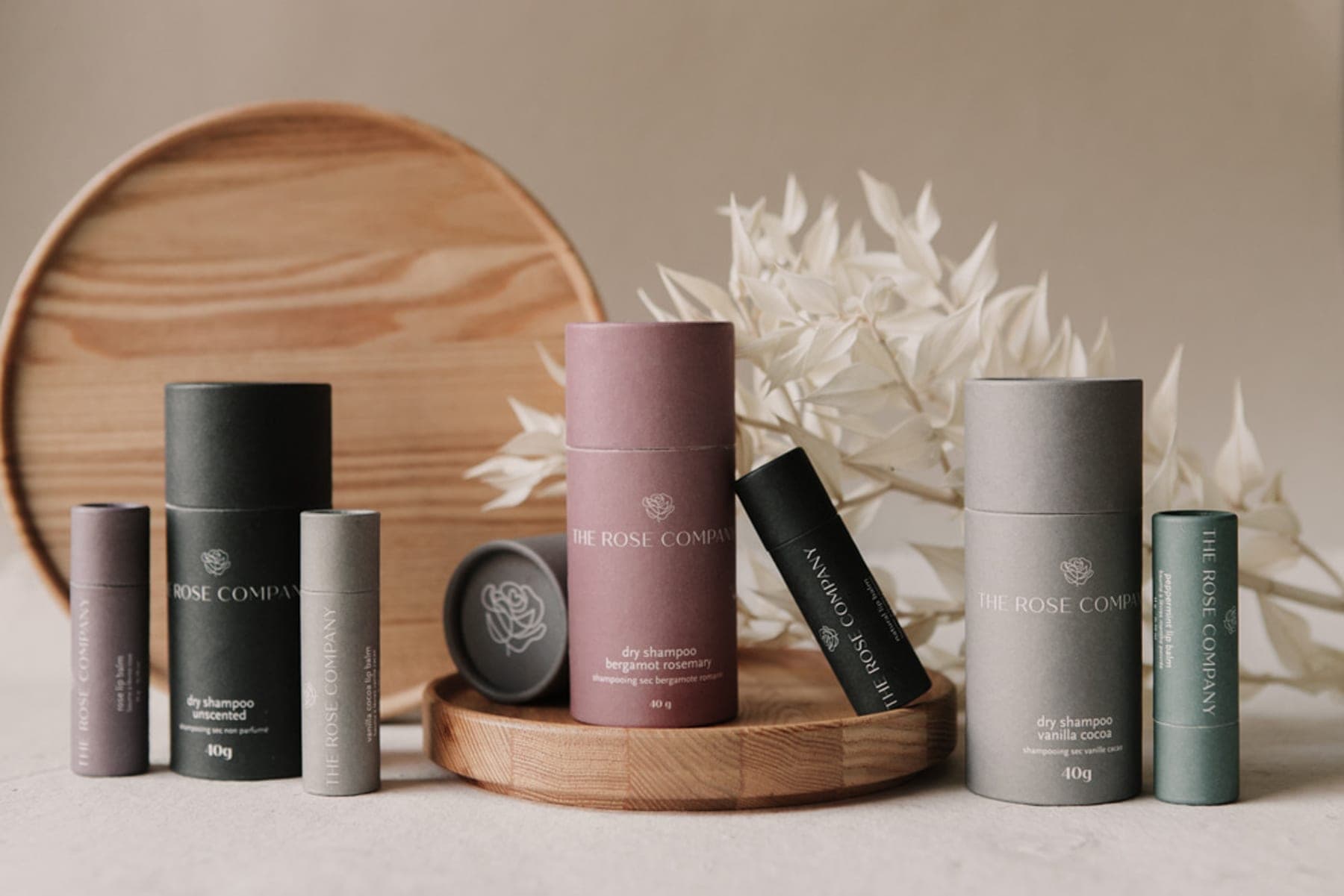 The Rose Company — paper-tube product lineup styled with dried botanicals
